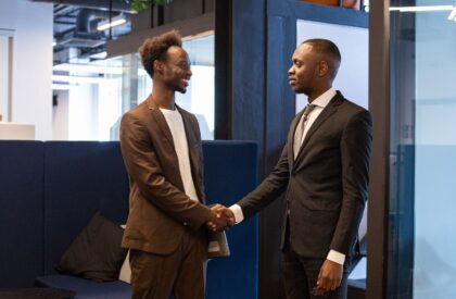 diaspora-tax-filing-2026-v3 Two African businessmen shaking hands in office