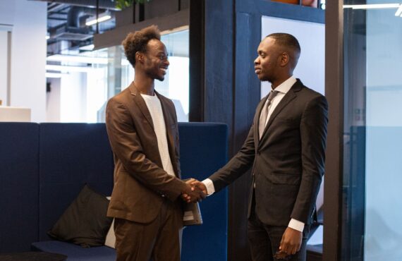 Two African businessmen shaking hands in office