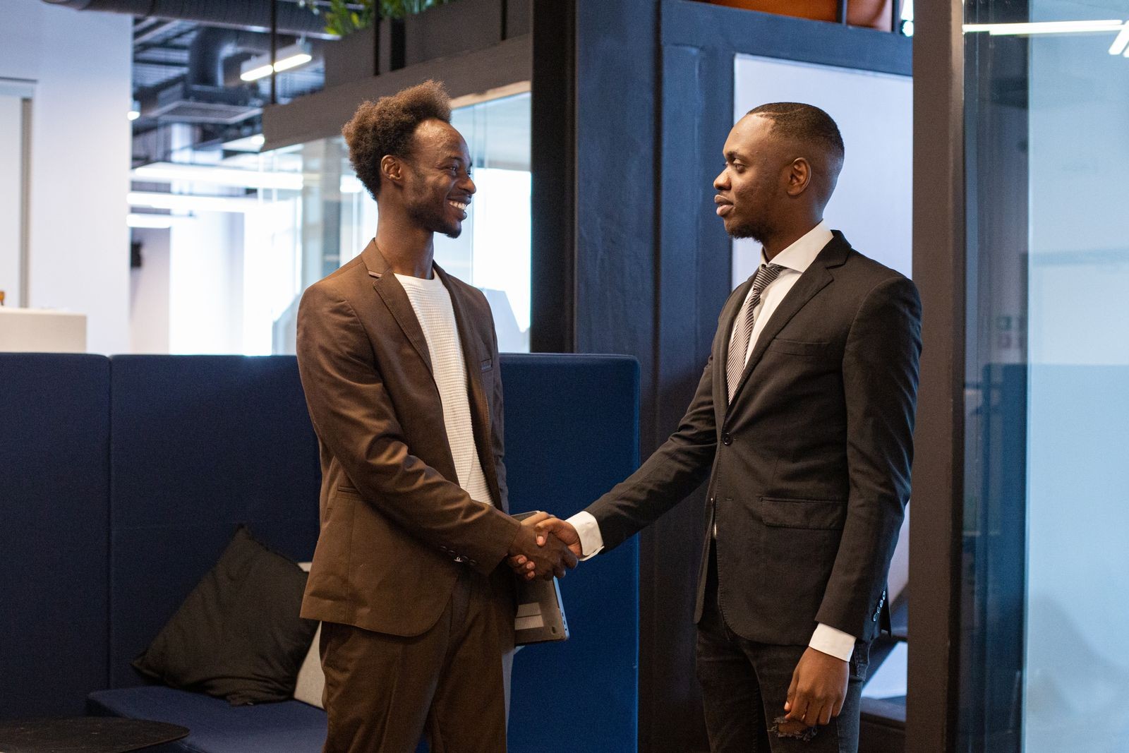 Two African businessmen shaking hands in office