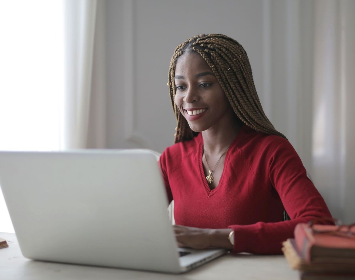 African woman working on a laptop at her desk