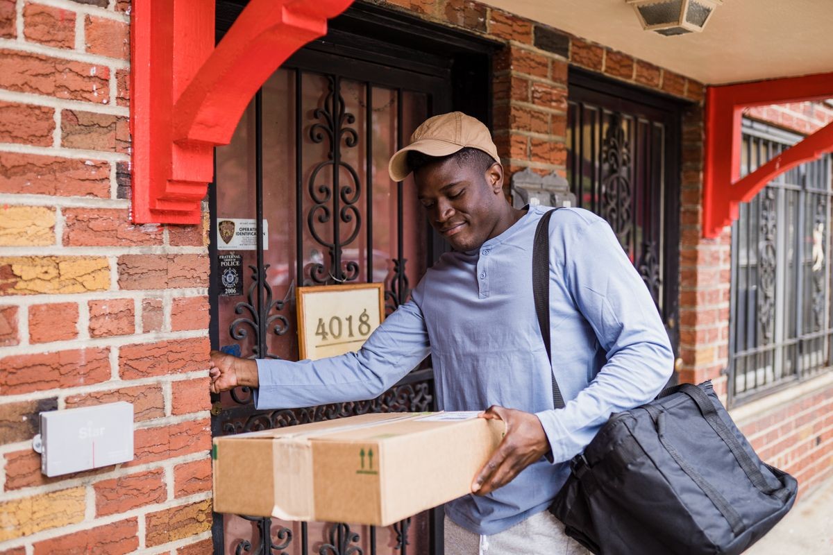 Delivery person handing a parcel package at a door