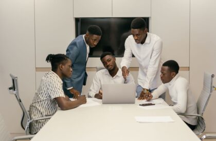 register-business-kenya-kra-guide-v3 African businessmen in a meeting discussing documents around a laptop